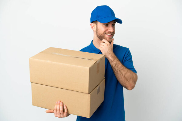 Delivery man over isolated white background looking to the side and smiling
