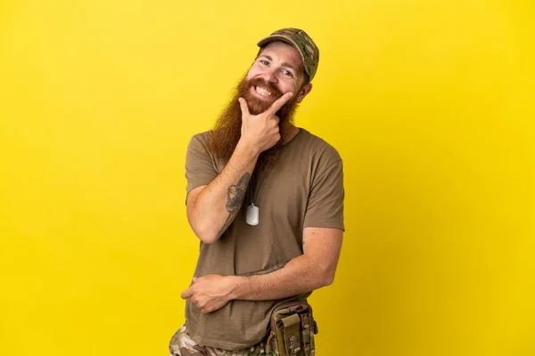 Rotschopf Militär Mann Mit Hundeanhänger Isoliert Auf Gelbem Hintergrund Lächelnd — Stockfoto