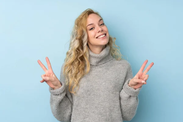 Jovem Loira Vestindo Uma Camisola Isolada Fundo Azul Mostrando Sinal — Fotografia de Stock