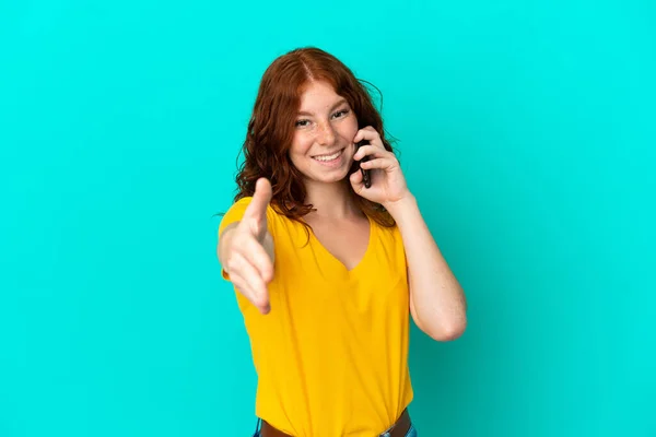 Adolescente Mulher Avermelhada Usando Telefone Celular Isolado Fundo Azul Apertando — Fotografia de Stock