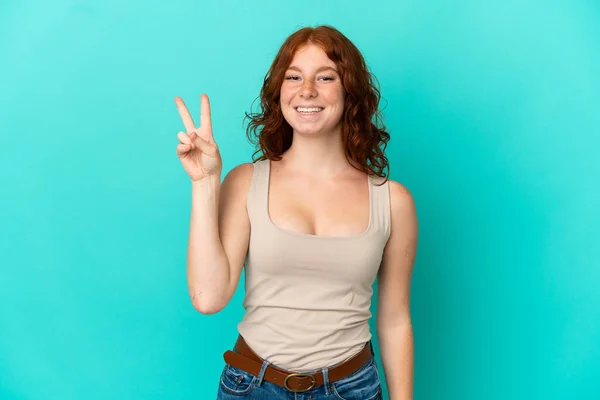 Teenager Reddish Woman Isolated Blue Background Smiling Showing Victory Sign — Stock Photo, Image