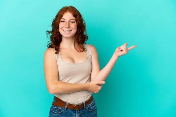 十代の赤の女性は 側に指を指す青の背景に隔離 — ストック写真