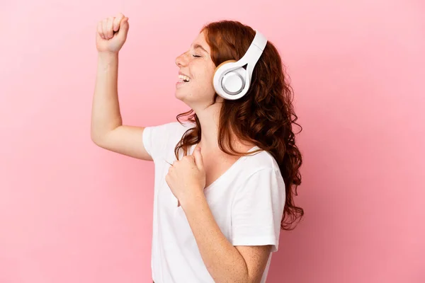 Adolescente Rougeâtre Isolée Sur Fond Rose Écoutant Musique Dansant — Photo