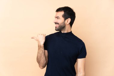 Kafkasyalı yakışıklı, soyutlanmış bir geçmişi olan bir adam bir ürün sunmak için kenarı işaret ediyor.