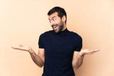 Kafkasyalı yakışıklı adam izole edilmiş arka planda iki eliyle kopyalama alanı tutuyor.