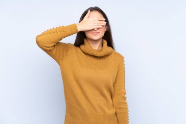 Mavi arka planda, gözleri elle kaplanmış beyaz bir kadın. Bir şey görmek istemiyorum.