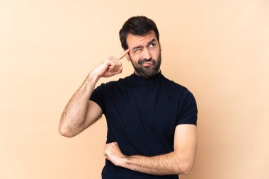 Kafkasyalı yakışıklı bir adam, izole edilmiş arka planda deliliğin hareketini yapıyor. Parmağını kafaya koyuyor.
