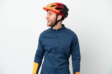 Genç bisikletçi beyaz arka planda izole edilmiş. Yan pozisyonda gülüyor.