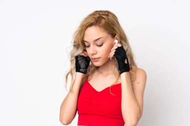 Genç sarışın kadın beyaz arka planda izole edilmiş müzik dinliyor.