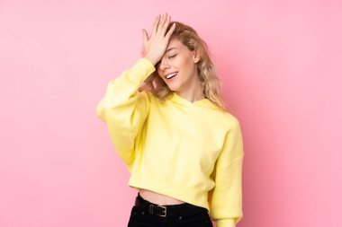 Pembe arka planda izole edilmiş sweatshirt giyen genç sarışın kadın bir şey fark etti ve çözümü arıyor.