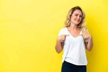 Sarı arka planda yalıtılmış Brezilyalı genç bir kadın. Sürpriz bir yüz ifadesi var.