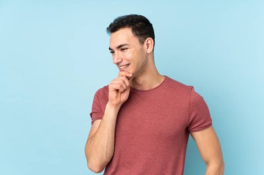 Beyaz tenli yakışıklı adam mavi arka planda izole edilmiş.