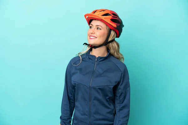 Junge Radfahrerin Isoliert Auf Blauem Hintergrund Und Denkt Beim Hochschauen — Stockfoto