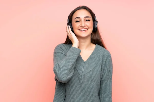 Joven Mujer Caucásica Aislada Sobre Fondo Rosa Escuchando Música —  Fotos de Stock