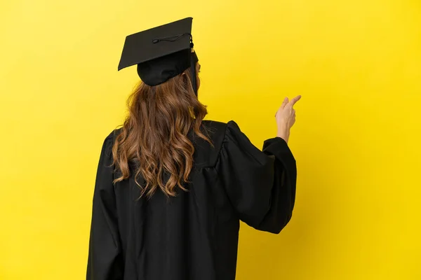 Middle Aged University Graduate Isolated Yellow Background Pointing Back Index — Stock Photo, Image