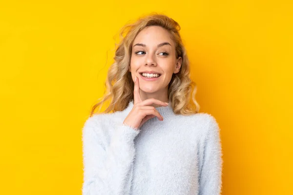 Jovem Loira Isolada Fundo Amarelo Pensando Uma Ideia Enquanto Olha — Fotografia de Stock