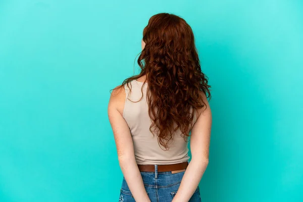 Adolescente Mujer Rojiza Aislado Sobre Fondo Azul Posición Espalda Mirando — Foto de Stock
