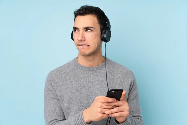 Young Caucasian Handsome Man Isolated Blue Background Listening Music Mobile — Stock Photo, Image