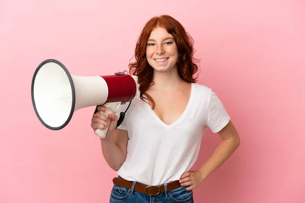 Tiener Roodachtig Vrouw Geïsoleerd Roze Achtergrond Met Een Megafoon Glimlachen — Stockfoto