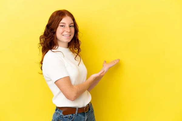 Adolescente Mulher Avermelhada Isolado Fundo Amarelo Estendendo Mãos Para Lado — Fotografia de Stock