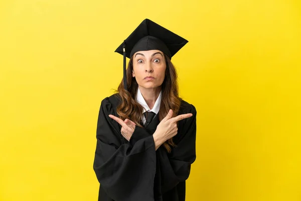 Middle Aged University Graduate Isolated Yellow Background Pointing Laterals Having — Stock Photo, Image