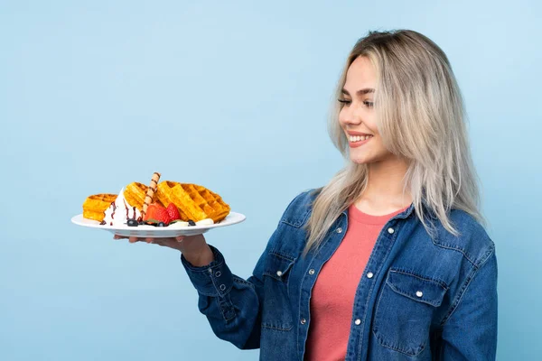 Tiener Meisje Houden Wafels Geïsoleerde Blauwe Achtergrond Met Gelukkige Expressie — Stockfoto