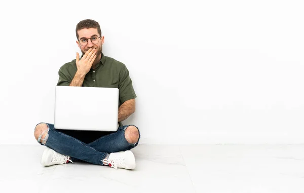 Jovem Sentado Chão Feliz Sorrindo Cobrindo Boca Com Mão — Fotografia de Stock