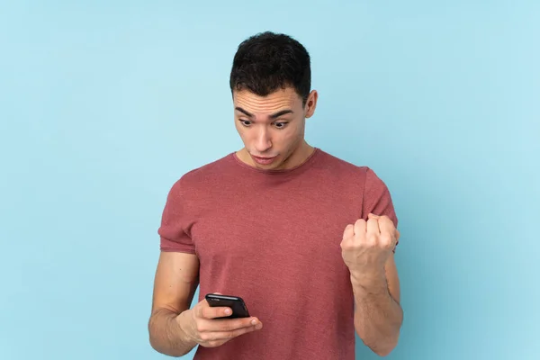 Jeune Homme Beau Caucasien Isolé Sur Fond Bleu Surpris Envoyant — Photo