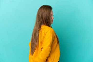 İzole edilmiş mavi arka planda genç bir kız.