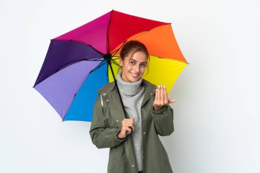 Elinde şemsiye tutan genç bir kadın beyaz arka planda izole edilmiş bir şekilde el ele gelmeye davet ediyor. Gelmene sevindim.