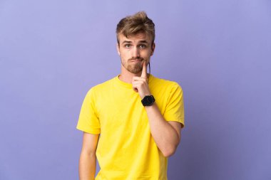 Mor arka planda soyutlanmış yakışıklı sarışın bir adam.