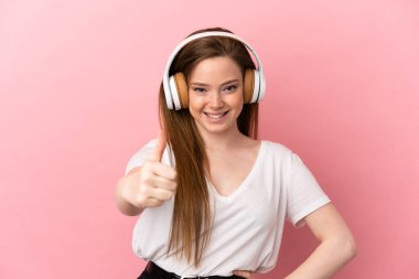 Soyutlanmış pembe arka planda genç bir kız müzik dinliyor ve başparmağıyla