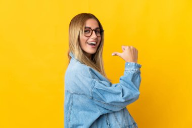 Sarı arka planda soyutlanmış genç sarışın kadın gururlu ve kendini beğenmiş.