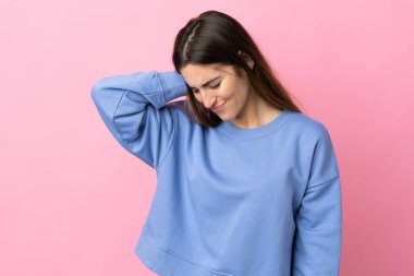 Pembe arka planda boynu ağrıyan beyaz bir kadın.