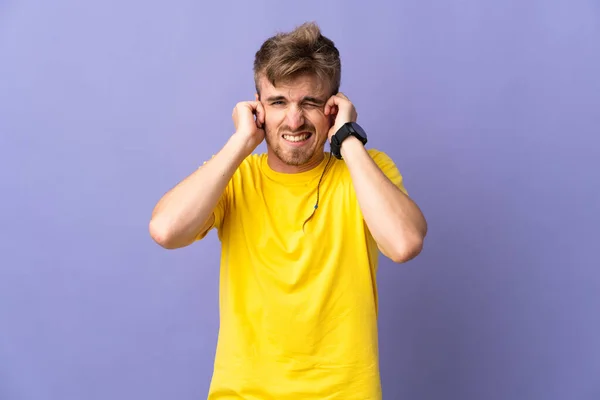 Mladý Pohledný Blondýnka Muž Izolovaný Fialové Pozadí Frustrovaný Zakrývající Uši — Stock fotografie