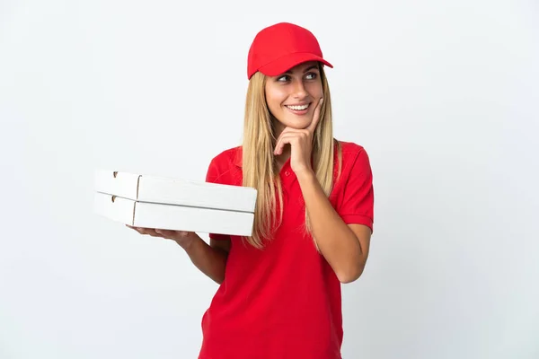 stock image Pizza delivery woman holding a pizza isolated on white background thinking an idea while looking up