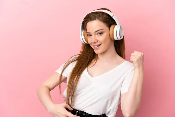 Девочка Подросток Изолированном Розовом Фоне Слушает Музыку Делает Гитарный Жест — стоковое фото