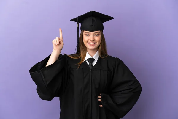 Graduação Universitária Jovem Sobre Fundo Roxo Isolado Apontando Para Uma — Fotografia de Stock