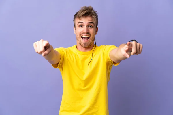 Jovem Homem Loiro Bonito Isolado Fundo Roxo Surpreso Apontando Frente — Fotografia de Stock