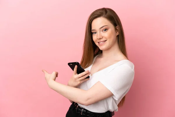 Adolescente Chica Sobre Aislado Rosa Fondo Utilizando Teléfono Móvil Apuntando — Foto de Stock