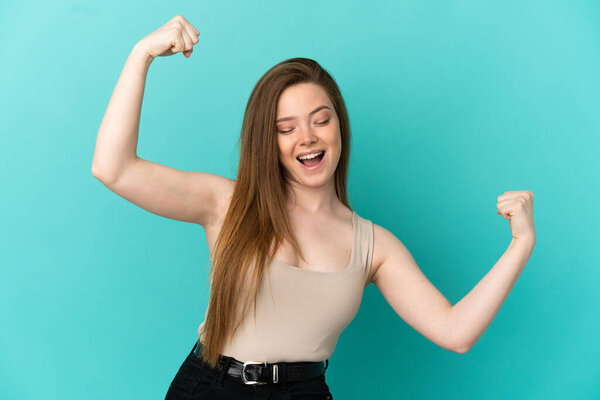 Teenager girl over isolated blue background celebrating a victory