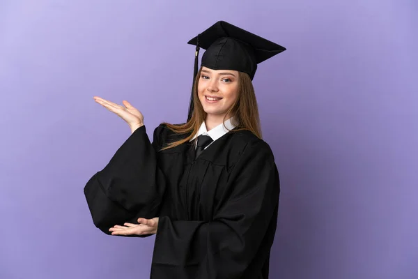 Joven Graduado Universitario Sobre Fondo Púrpura Aislado Extendiendo Las Manos — Foto de Stock