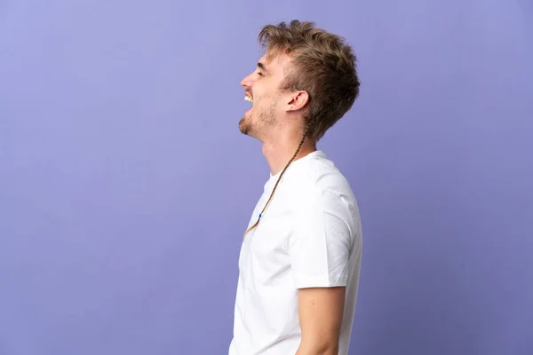 Jong Knap Blond Man Geïsoleerd Paarse Achtergrond Lachen Laterale Positie — Stockfoto