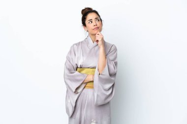 Woman wearing kimono over isolated background and looking up