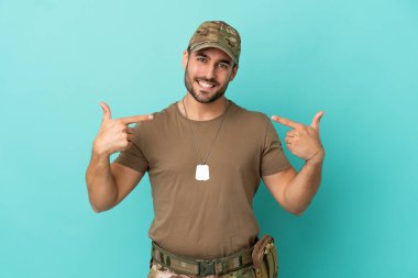 Mavi arka planda izole edilmiş, gururlu ve kendini beğenmiş bir asker.