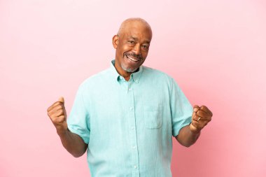 Kübalı son sınıf öğrencisi pembe arka planda galibiyeti kutluyor.