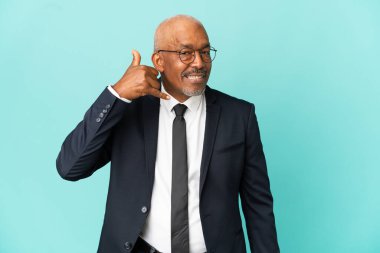 İşletme son sınıf öğrencisi mavi arka planda izole edilmiş, telefon jesti yapıyor. Bana geri dönüş işareti ver.