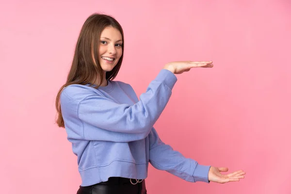 Tiener Kaukasisch Meisje Geïsoleerd Roze Achtergrond Holding Copyspace Naar Een — Stockfoto