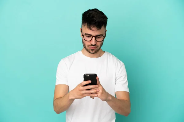 Genç Beyaz Adam Mavi Arka Planda Cep Telefonu Kullanarak Izole — Stok fotoğraf