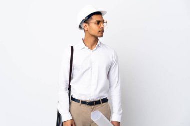 Miğferli ve elinde izole edilmiş beyaz arkaplan üzerine planlar tutan Afrikalı Amerikalı mimar.